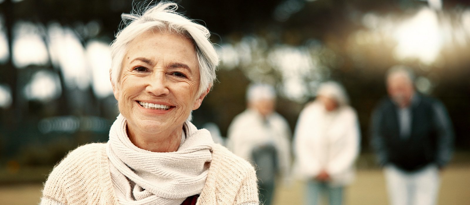 Face, senior woman and smile in nature on vacation, holiday or travel in winter. Portrait, happy and elderly person in the countryside, park or garden for wellness, freedom or fresh air in retirement.